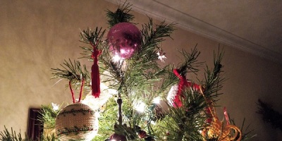 a decorated Christmas tree topped with a purple ball ornament