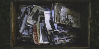 old photos piled in a wooden box