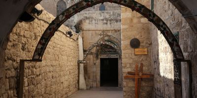 A view of an entrance to the Coptic Orthodox Patriarchate in Jerusalem, with arches topped with crosses on the pathway