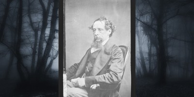 black and white portrait of novelist Charles Dickens sitting in a chair
